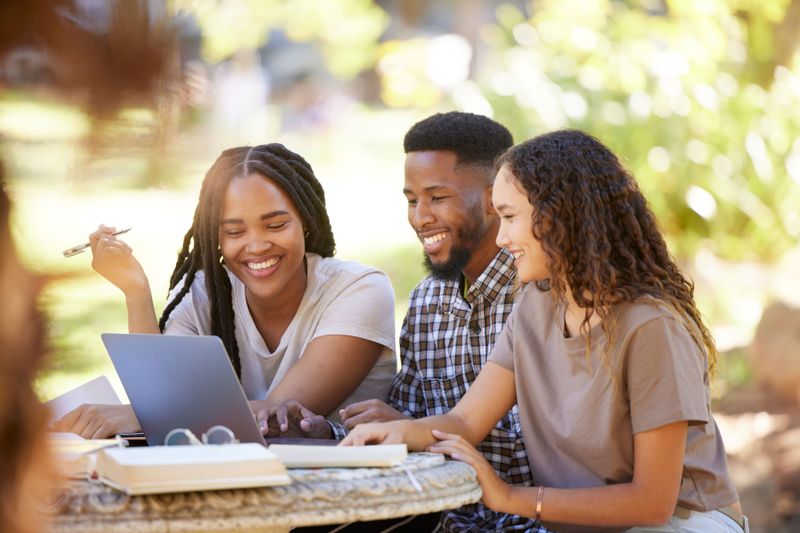 Happy students studying outside on a sunny day