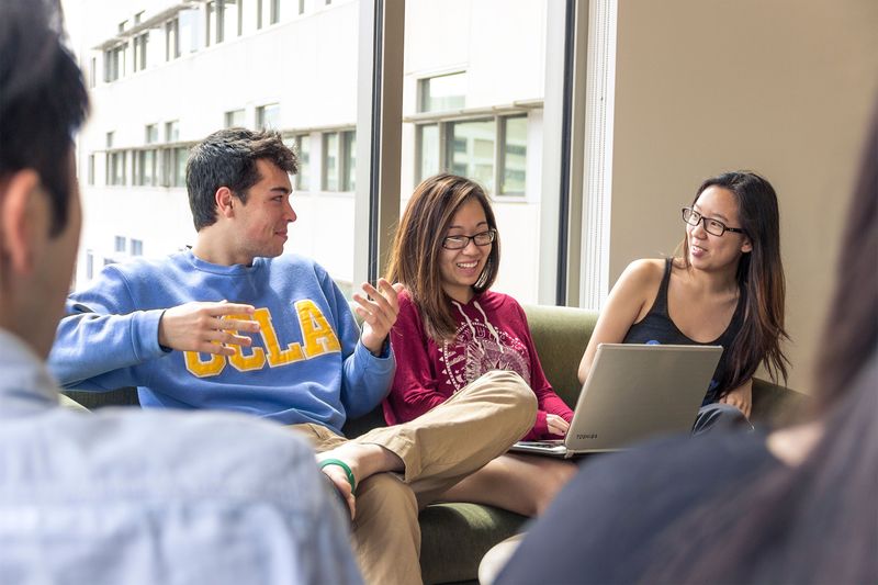 Students sitting on a sofa talking with each other